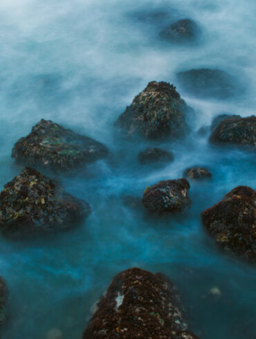 A long exposure photo of a rocky seashore on the California coast