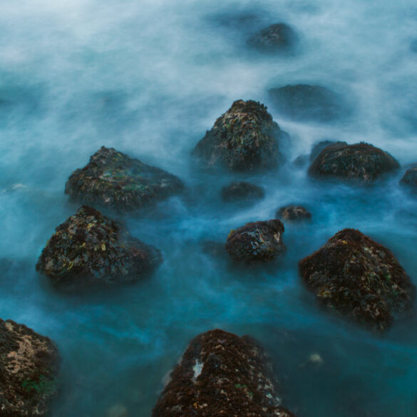 A long exposure photo of a rocky seashore on the California coast